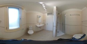Ein modernes Badezimmer mit Toilette, Waschbecken und Dusche.