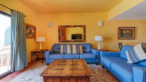 A living room with a blue sofa, a wooden coffee table, and two lamps. - Paradise Villa 19 by Kivoya (Puerto Peñasco)