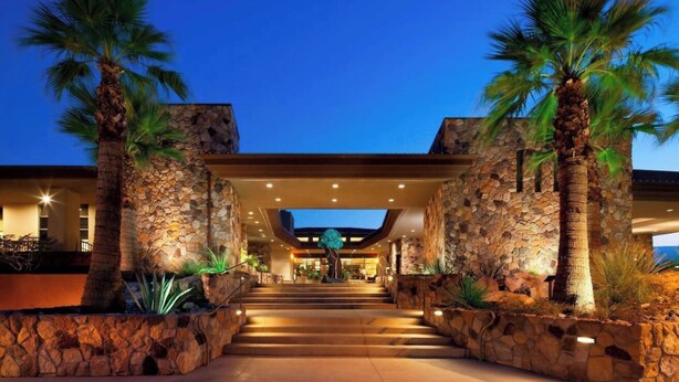A stone entrance with palm trees, a staircase leading to a covered area, and a view of the building's interior. - Luxurious Resort Stay, 2br lock off at Westin Palm Desert (Palm Desert)