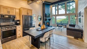 A modern kitchen with wooden cabinets, stainless steel appliances, and a large island. - Mountain Abode - Hot tub & mountain views (Blue Ridge Mountains)