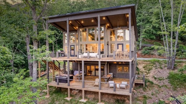 A multi-level wooden cabin with a deck, surrounded by forest. - Mountain Abode - Hot tub & mountain views (Blue Ridge Mountains)