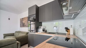 Eine moderne Küche mit integrierter Kaffeemaschine, Spüle und Glasrückwand.