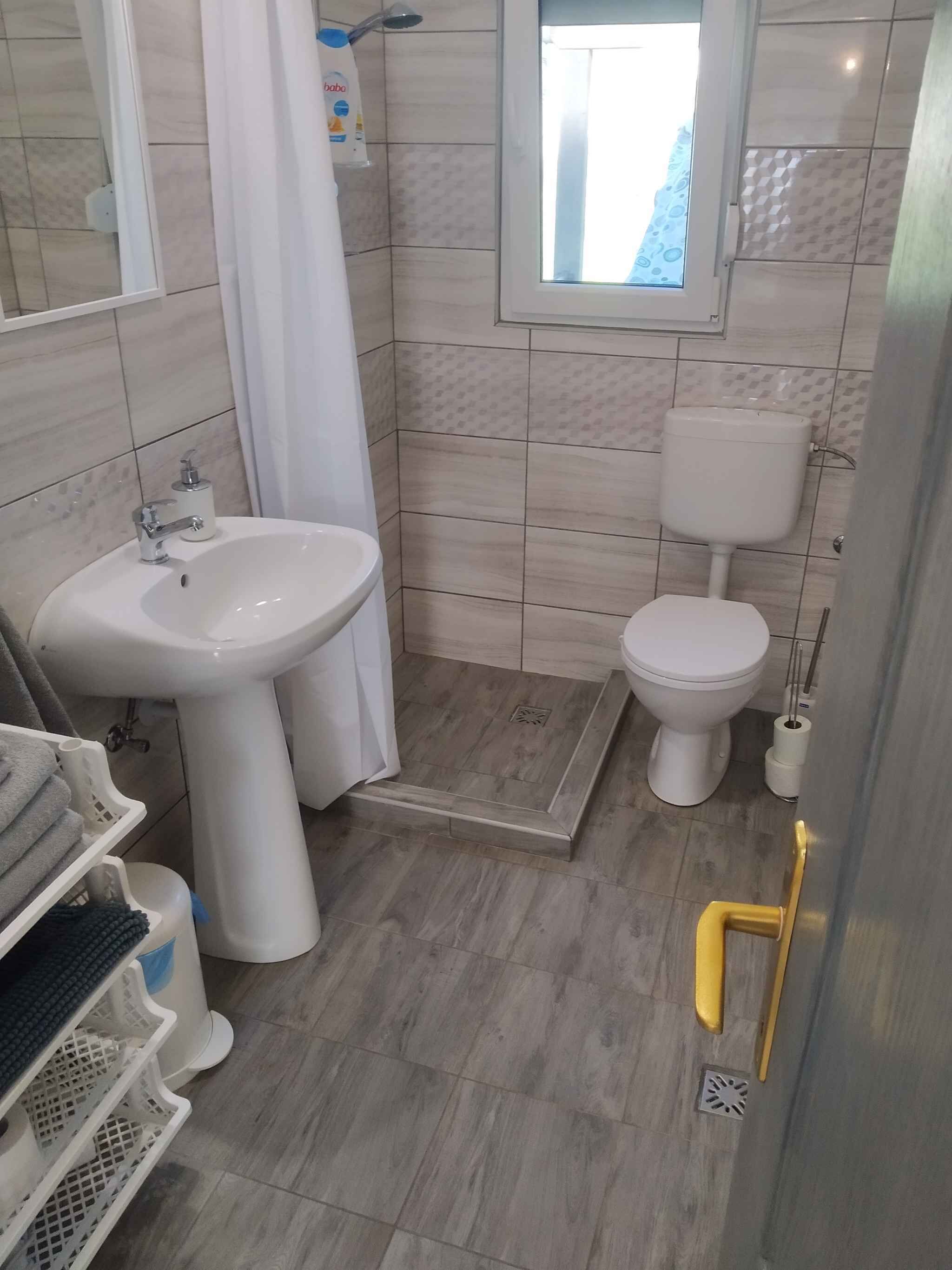 A bathroom with a sink, toilet, and shower.