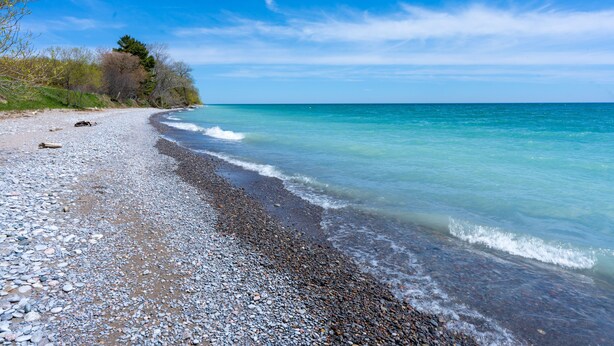 A pebbled beach with clear turquoise water and a clear sky. - Lakeside Modern House 4BR - Steps to the lake (Bowmanville)