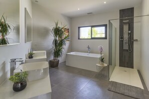 Een bad/douchecombinatie, handdoeken, toiletpapier