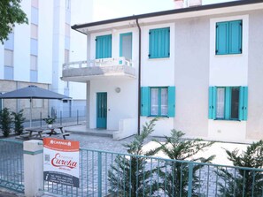 A two-story building with teal shutters, a balcony, and a sign advertising 'Eureka Welcome.'