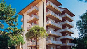 A multi-story building with balconies, likely a hotel or apartment complex. - Holiday apartment with balcony and air conditioning (Lignano Sabbiadoro)
