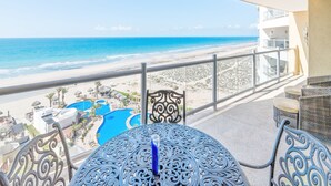 A balcony with a view of the beach and ocean.