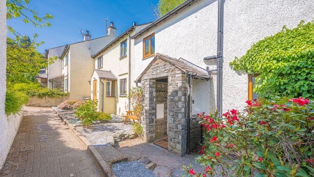 A narrow street with traditional stone houses, a stone-built entrance, and a gravel pathway. - Brook Cottage - village cottage close to pubs and walks (Coniston)