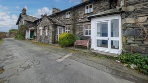 Un hilera de casas de piedra con una calle pavimentada al frente.