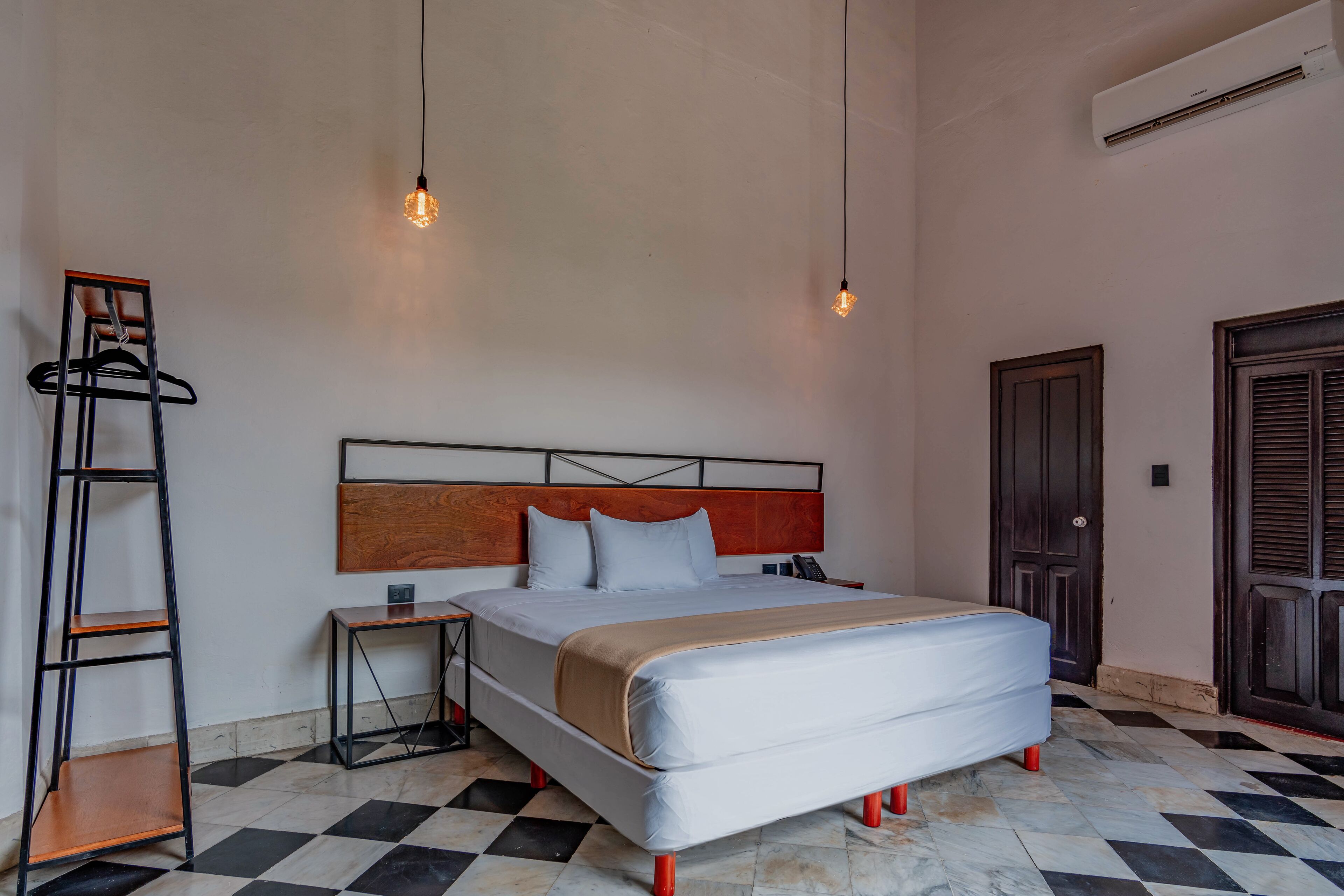 A bedroom with a bed, a nightstand, a ladder, and a wardrobe.
