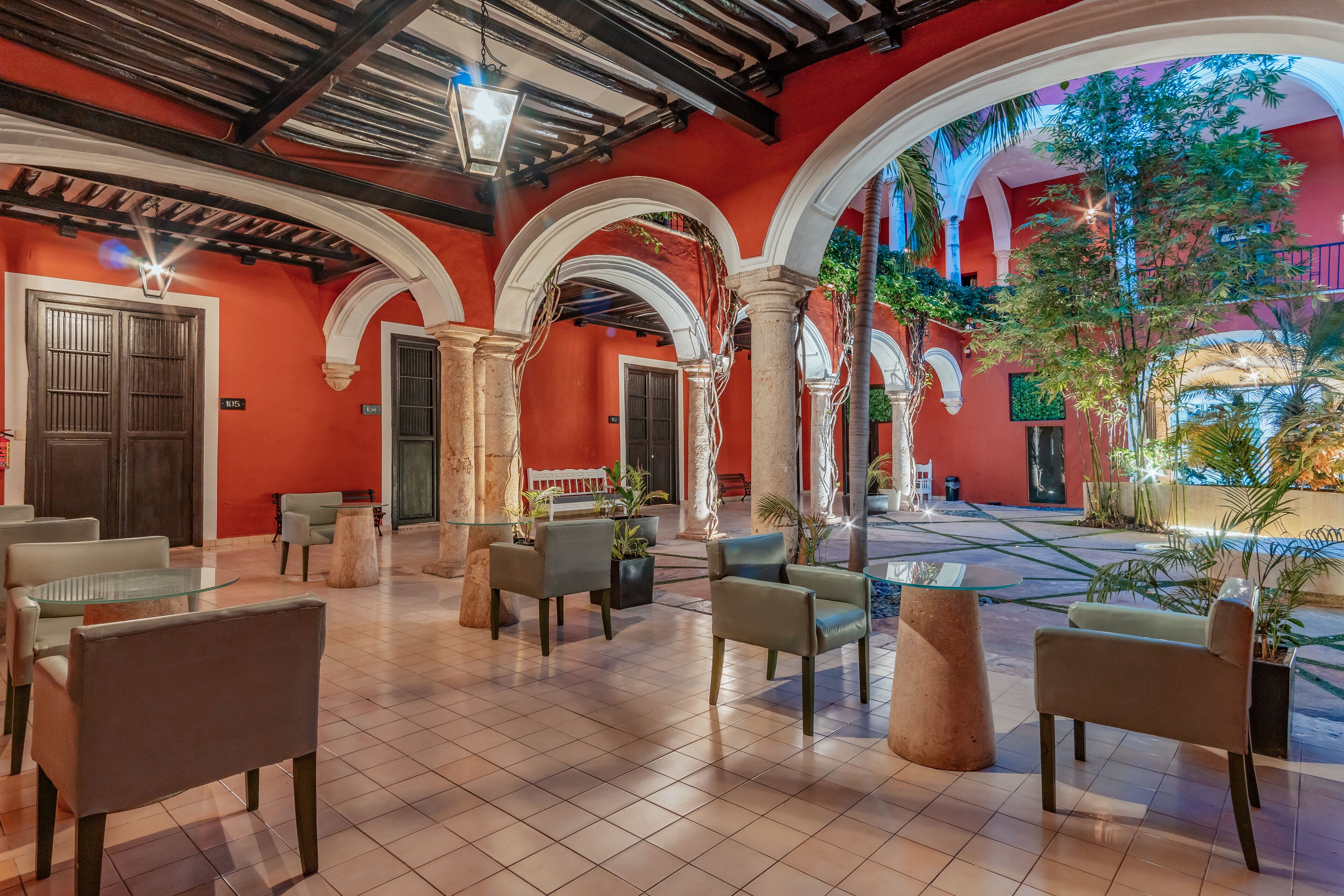 A spacious lobby with a tiled floor, multiple seating areas, and a view of the outdoor courtyard.