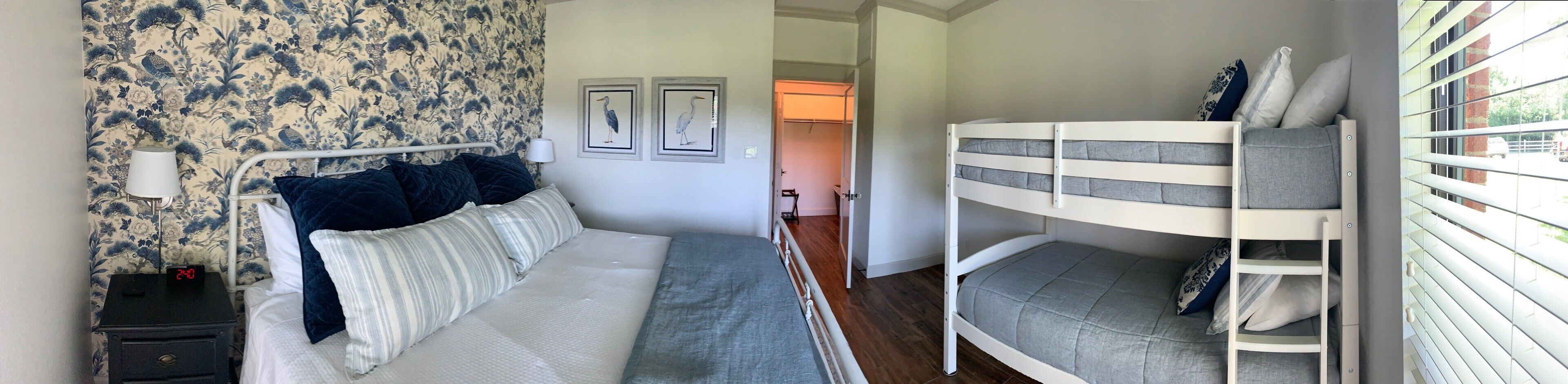 Un dormitorio con cama, mesita de noche y literas.