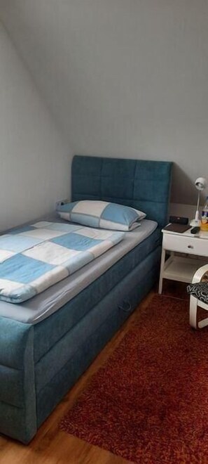 Cozy retreat with a single bed, nightstand, and table, perfect for a restful stay.