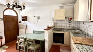 Una cucina compatta con zona pranzo, una porta in legno e uno schienale piastrellato.