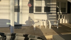 Ein Haus mit einer Veranda, einem Tisch und Stühlen.