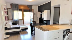 A modern apartment with a living area, kitchenette, and a dining space. - Holiday apartment in a quiet and central location, completely renovated (Bibione)