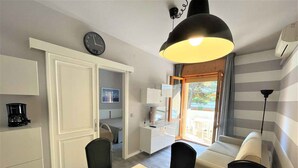 A compact living space with a dining area, kitchenette, and a sofa.