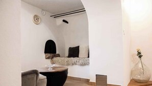 A cozy living area with a sofa, a round coffee table, a chair, a clock, and a vase with a flower. - Holiday home with air conditioning and sea view (Vidovici)
