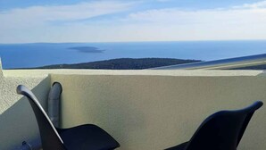 A balcony with a view of the sea and a distant island. - Holiday home with air conditioning and sea view (Vidovici)