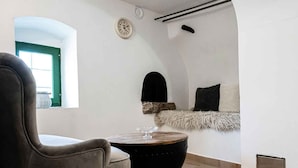 A modern interior with a curved ceiling, a round wooden table, a leather chair, and a small clock on the wall. - Holiday home with air conditioning and sea view (Vidovici)