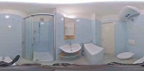 Un baño moderno con ducha envuelta en vidrio, lavabo e inodoro.