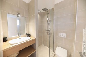 A modern bathroom with a glass-enclosed shower, a sink with a mirror, and a toilet. - Near beach, Apartment 2 rooms air-conditioned (PORT GRIMAUD)