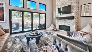 Ein geräumiges Wohnzimmer mit großem Fenster, Kamin und einer gemütlichen Sitzecke.