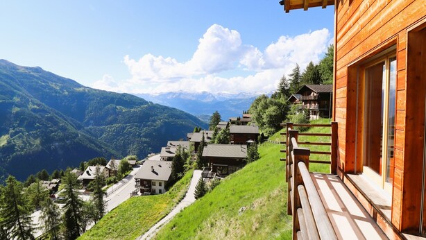 A wooden chalet with a balcony overlooking a mountainous landscape. - Outside: Detached chalet on 3 floors with magnificent views, for 4 people - approx. 80m2Inside: Brig (St-Luc)