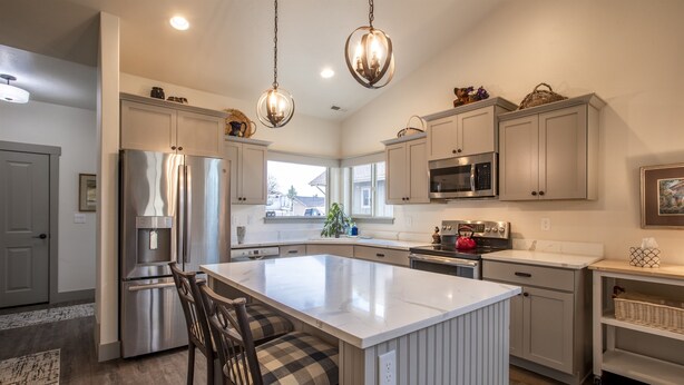 A modern kitchen with a central island, stainless steel appliances, and pendant lighting. - Perfect Golf Getaway near Glacier, 2/2 townhome right on golf course (Kalispell)
