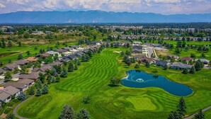 An aerial view of a residential area with houses, a golf course, and a lake. - Perfect Golf Getaway near Glacier, 2/2 townhome right on golf course (Kalispell)