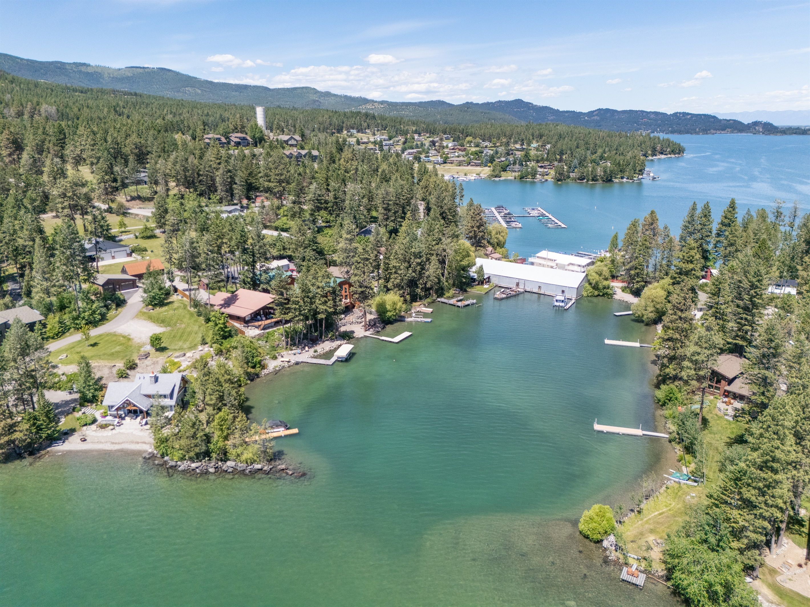 Vue aérienne d’une propriété au bord du lac, comprenant plusieurs bâtiments, des quais et une marina.