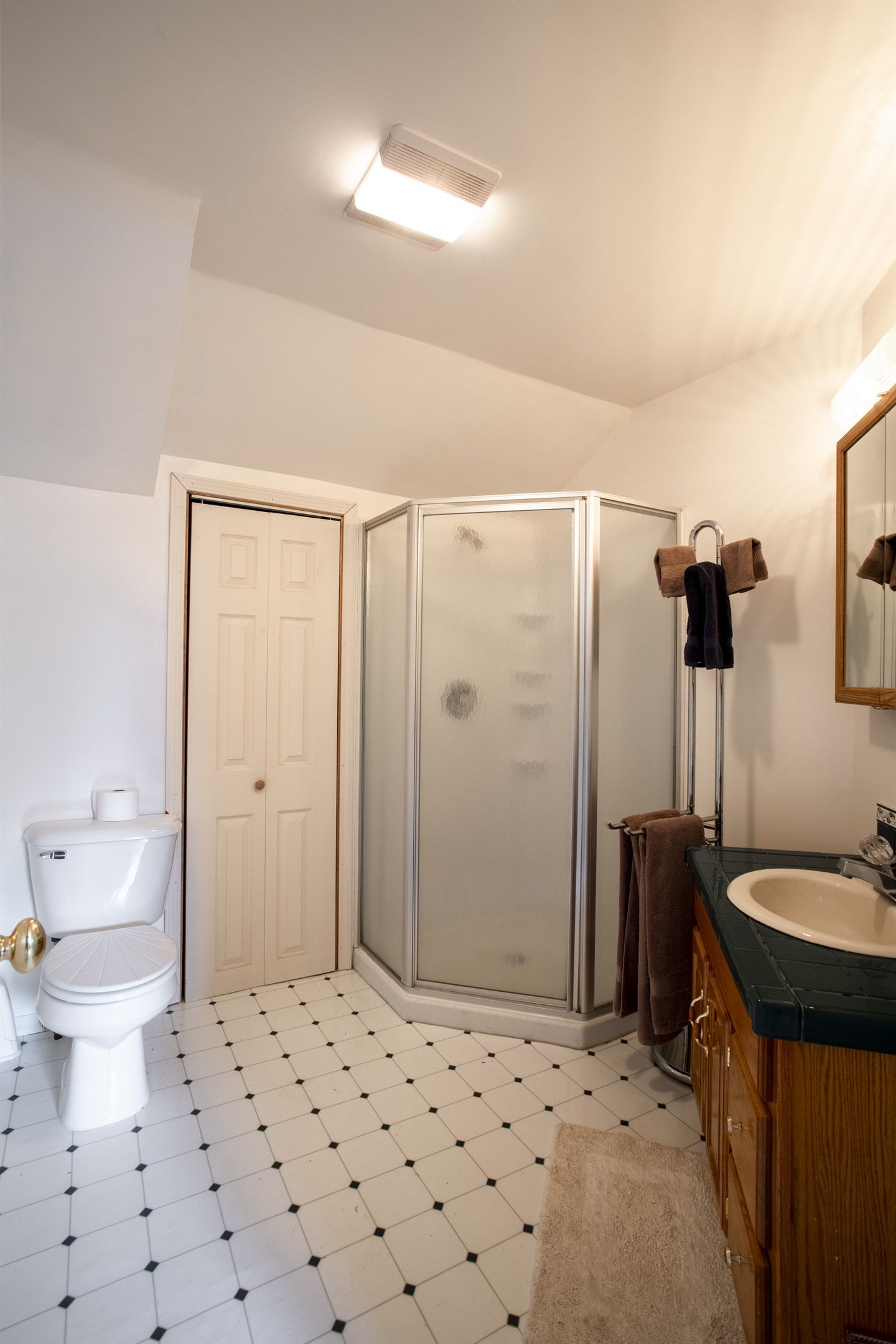 A bathroom with a toilet, a shower enclosure, and a sink.