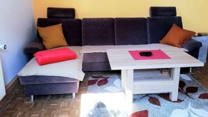 Un salon avec un canapé, une table basse et un tapis à motifs.