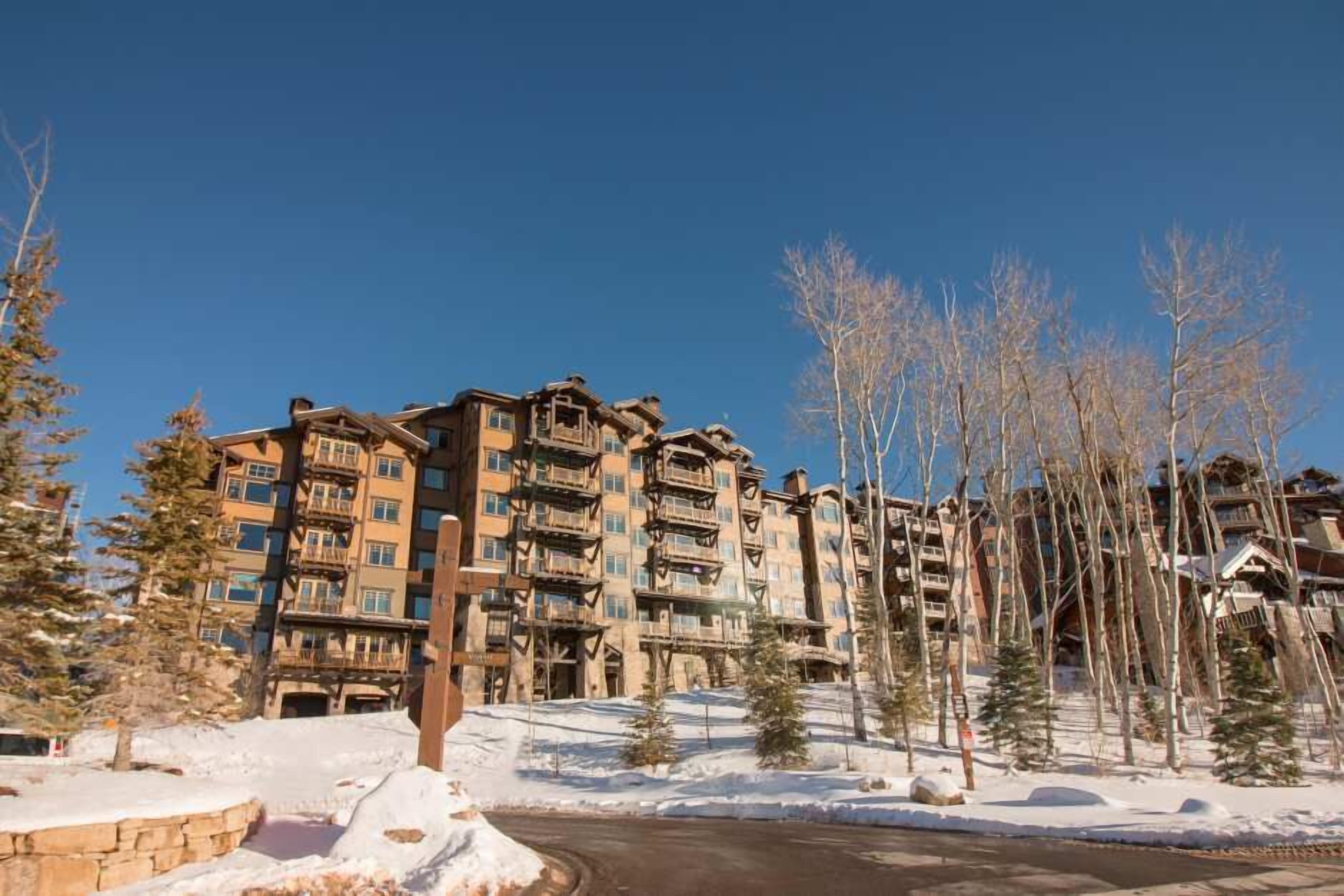 A multi-story hotel with balconies, surrounded by snow-covered ground and leafless trees.