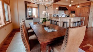 A dining area with a wooden table, leather chairs, and a chandelier. - Silver Strike by Park City Vacations (Park City)