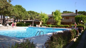 Una piscina con sillas de descanso y un suelo de baldosas.