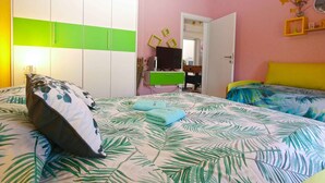 Un dormitorio con cama, armario, escritorio y televisor.