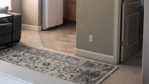 A kitchen with a refrigerator, cabinets, and a dining area with a table and chairs. - Private, comfy and cozy apartment in family neighborhood (Oregon City)