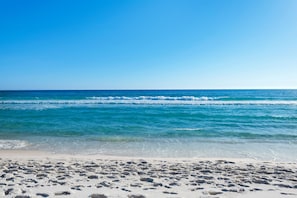 Ein Strand mit klarem, blauem Wasser und einem Sandstrand.