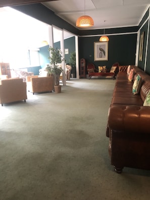 Relax in the spacious living room with a sofa and wicker chairs, perfect for unwinding.