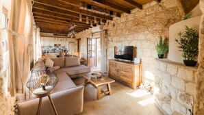 A cozy living room with a sofa, a coffee table, and a TV on a wooden cabinet.