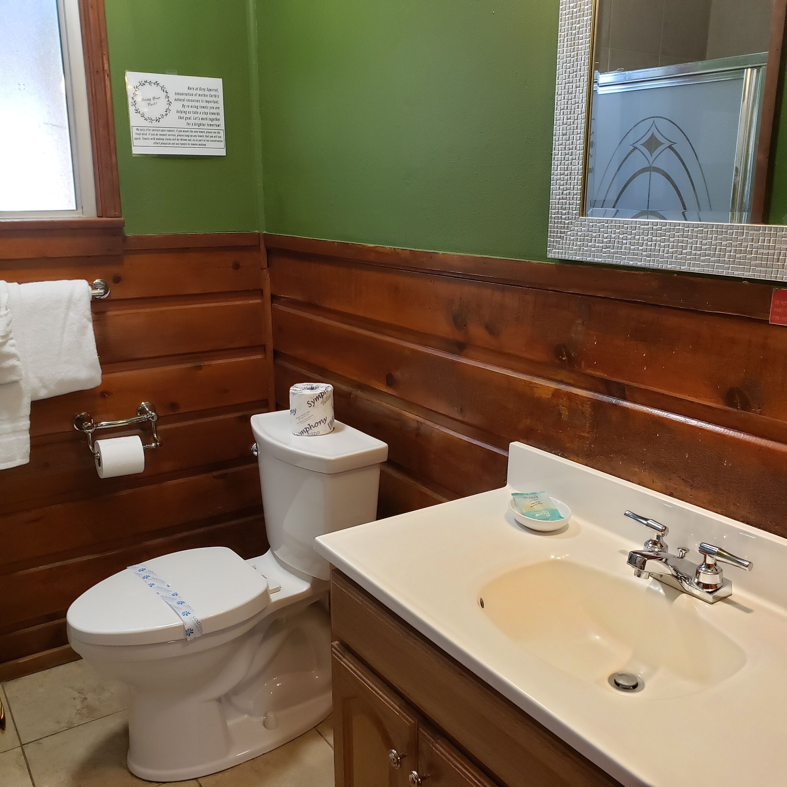 Ein Badezimmer mit einem Holzkonsolentisch, einem Waschbecken und zwei Toiletten.