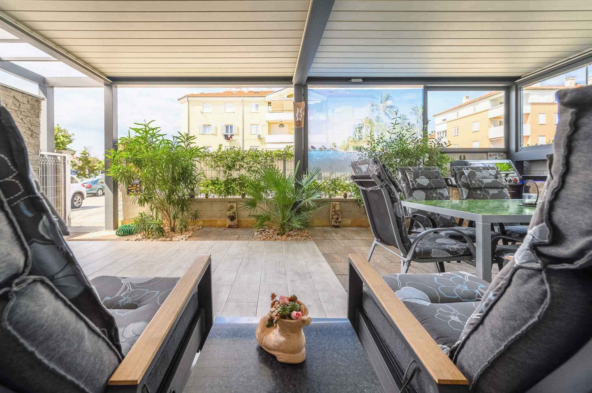 Un espacio de estar al aire libre cubierto con vistas a edificios y vegetación.