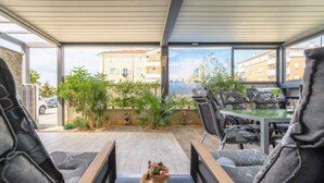 A covered outdoor seating area with a view of buildings and greenery.