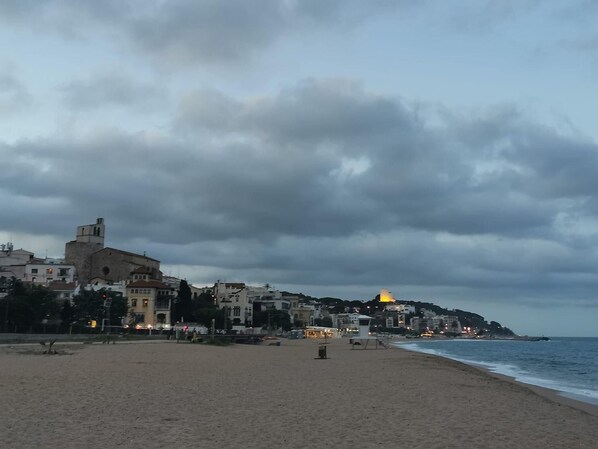 A beach with buildings and a church in the background.