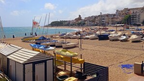 Een strand met boten en een vlag.