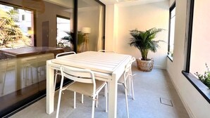 Een modern interieur met een eettafel en stoelen, een hanglamp en een potplant.