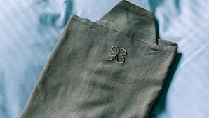 A neatly folded piece of clothing with a visible button on the cuff.
