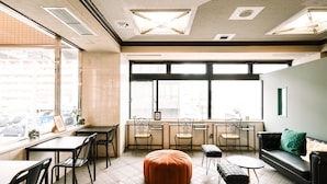 A modern interior with a dining area, seating, and large windows.